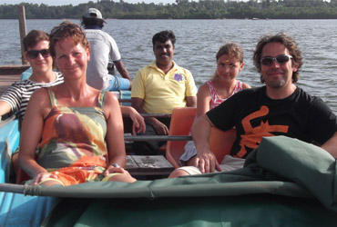 Tourist enjoying fish foot massage during Madu River Safari in Sri Lanka